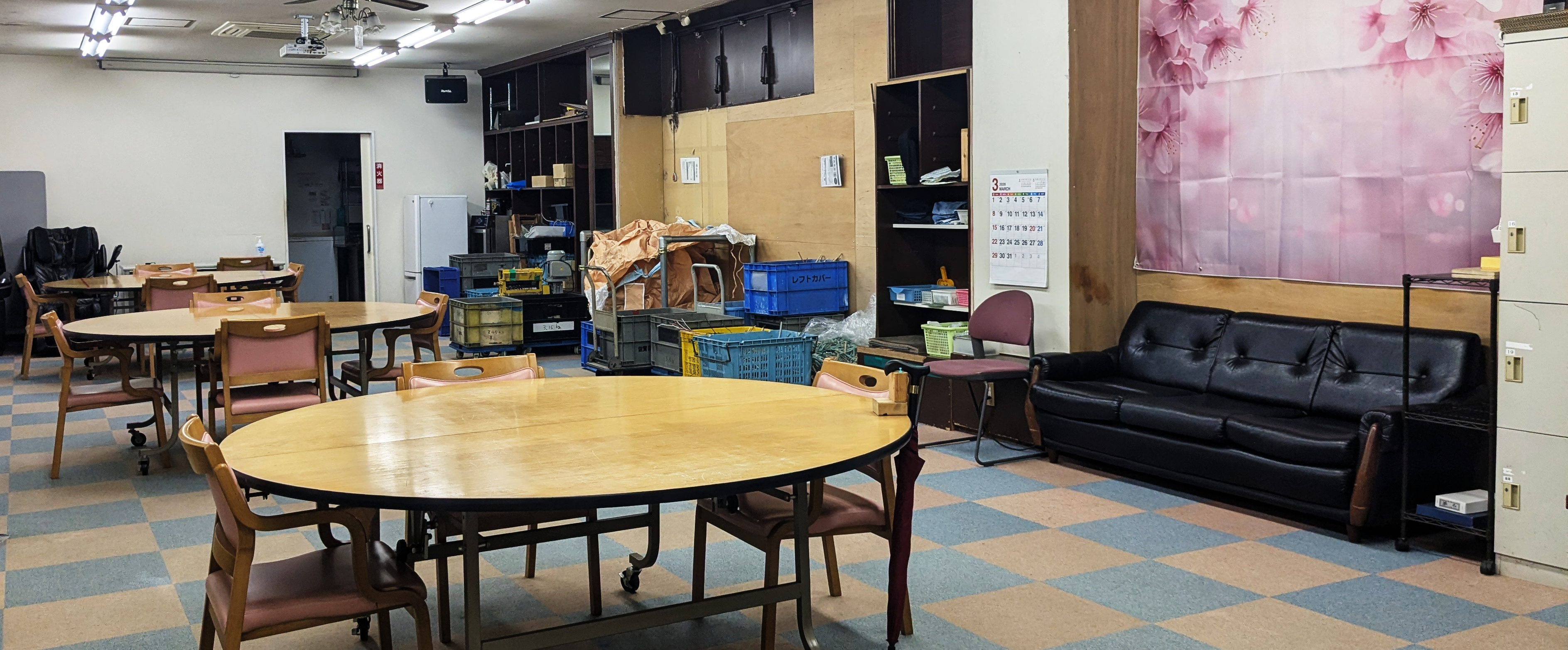 久留米市の就労継続支援B型事業所、東町公園「つどい」の作業場の様子。スタッフと利用者が一緒に作業している。